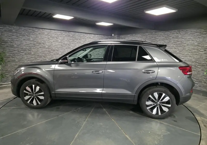 Volkswagen T-Roc gris en profil droit, avec jantes alliage 17 pouces et sticker édition GOAL sur custode arrière.