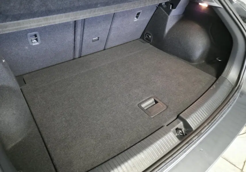 Coffre spacieux du Volkswagen T-Roc gris 2025 vu de dessus, avec plancher plat et éclairage intérieur.