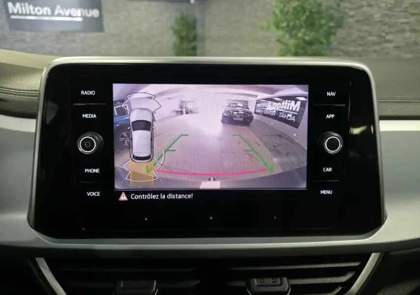 Écran tactile intérieur affichant la caméra de recul avec guidage dynamique du Volkswagen T-Roc gris.