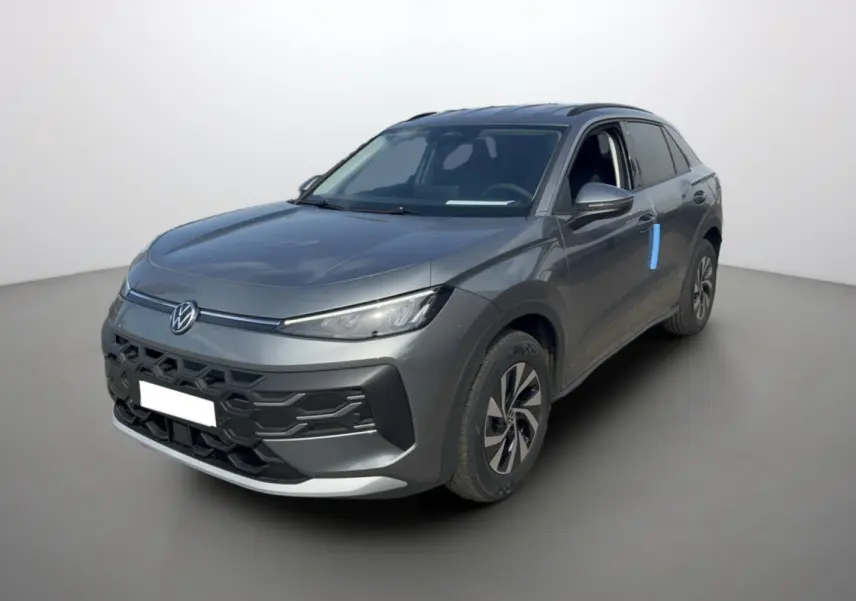 Volkswagen T-Roc gris loup en 3/4 avant droit, avec calandre noire et jantes alu bicolores visibles.