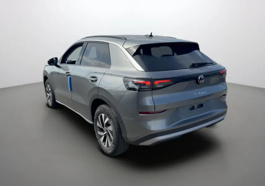 Vue 3/4 arrière gauche d'un Volkswagen T-Roc gris loup 2026 avec feux arrière LED et jantes alu 16 pouces.