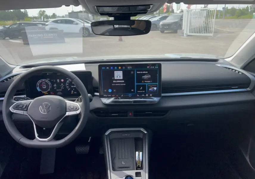 Vue intérieure frontale du tableau de bord du Volkswagen T-Roc gris loup 2026 avec écran tactile central et volant multifonctions cuir.