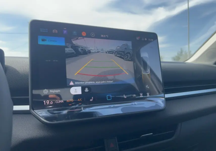 Écran tactile intérieur du Volkswagen T-Roc 2026 montrant la caméra de recul avec affichage des lignes d'aide au stationnement.