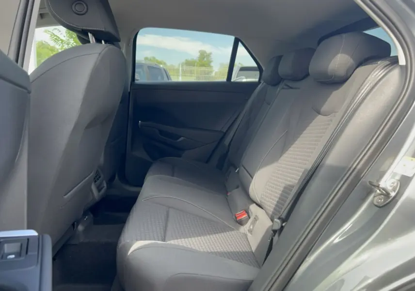 Vue intérieure côté droit sur la banquette arrière grise tissu du Volkswagen T-Roc 2026, avec ouverture de porte.