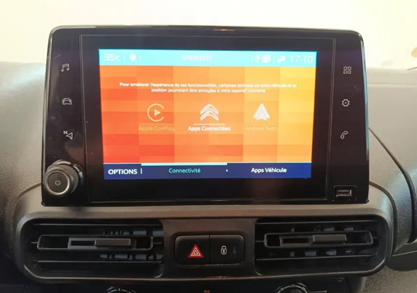 Écran tactile central allumé avec interface Apple CarPlay et Android Auto dans le tableau de bord d'un Citroën Berlingo blanc.