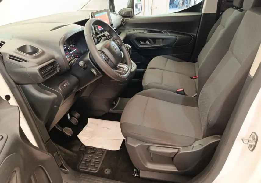 Vue intérieure côté conducteur du Citroën Berlingo blanc 2020, avec tableau de bord et sièges gris visibles.