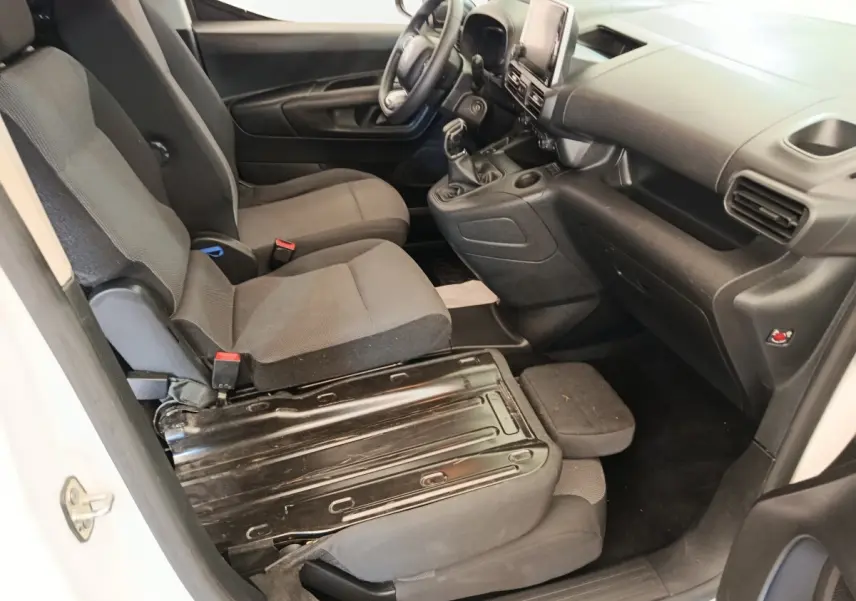 Vue intérieure côté conducteur du Citroën Berlingo blanc 2020, montrant sièges avant et tableau de bord noir.