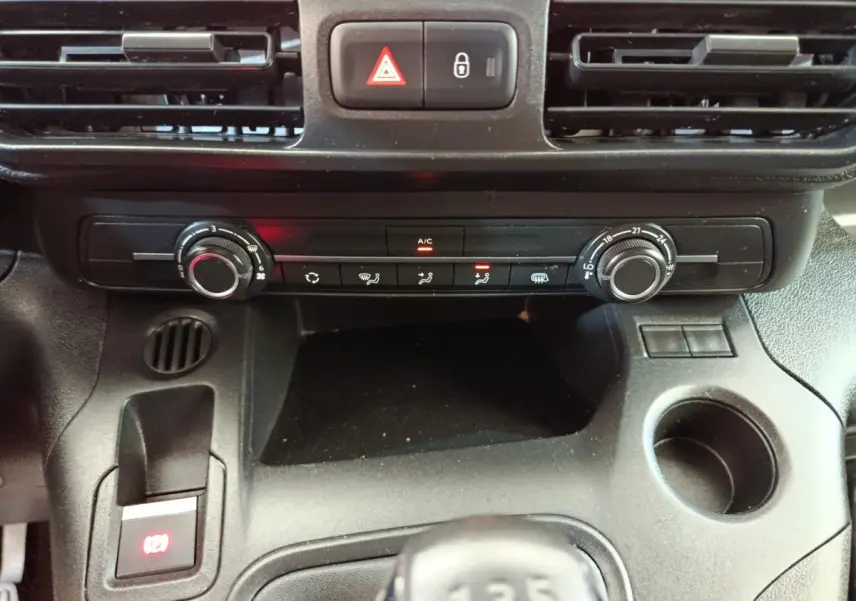Vue rapprochée de la console centrale noire du Citroën Berlingo 2020, avec commandes climatisation et levier de vitesses manuel.