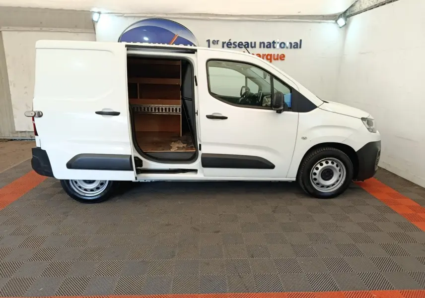 Vue de profil droit d'un utilitaire Citroën Berlingo blanc 2020 avec porte latérale coulissante ouverte montrant l'intérieur de chargement.