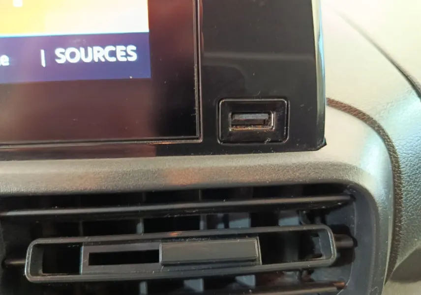 Gros plan sur la prise USB et la grille d’aération du tableau de bord central du Citroën Berlingo blanc de 2020.