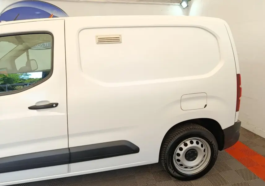 Vue latérale droite d’un utilitaire Citroën Berlingo blanc avec porte latérale pleine et jante acier.