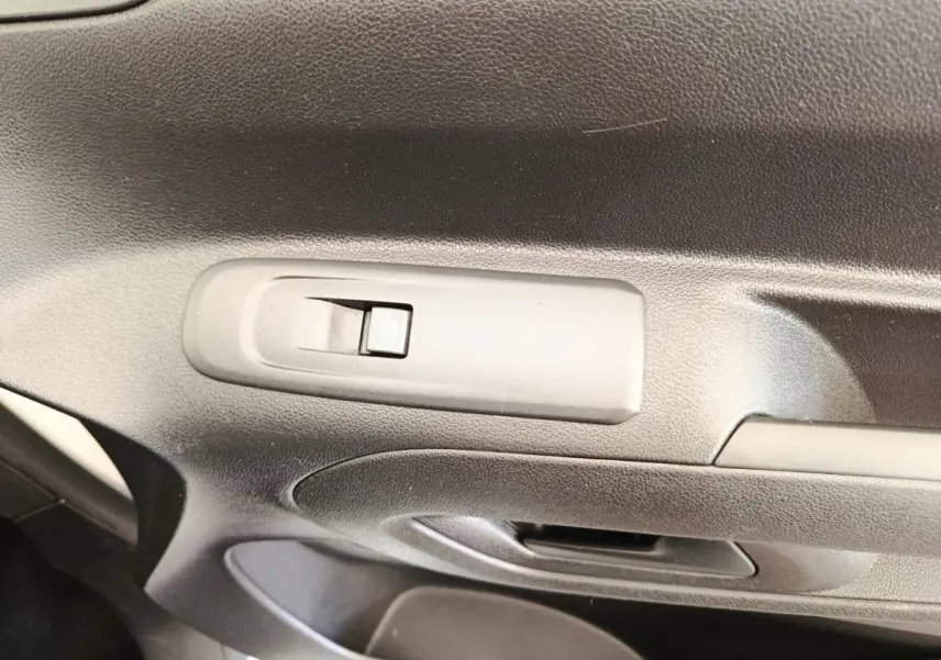 Gros plan sur la poignée de porte intérieure noire du Citroën Berlingo blanc, version M 1000kg BlueHDi 2020.