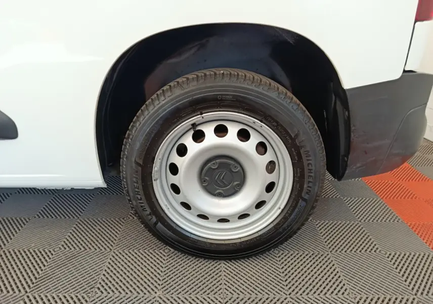 Gros plan sur la roue arrière droite en jante acier grise du Citroën Berlingo blanc, avec logo Citroën au centre.