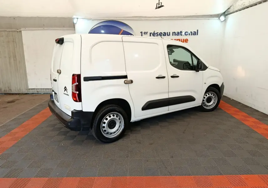 Vue 3/4 arrière droite d’un utilitaire Citroën Berlingo blanc avec porte latérale coulissante et jantes acier.