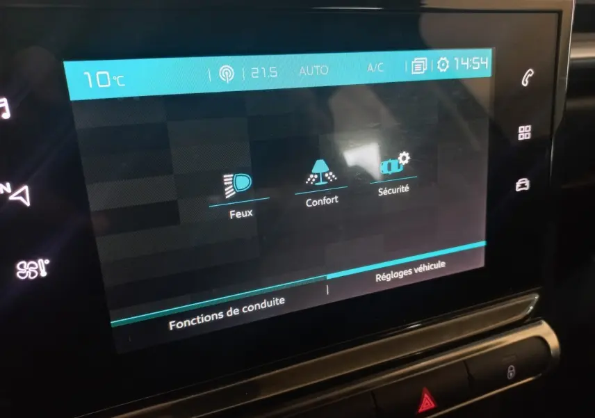 Écran tactile central de la Citroën C3 2024 affichant les réglages Feux, Confort et Sécurité en intérieur noir.