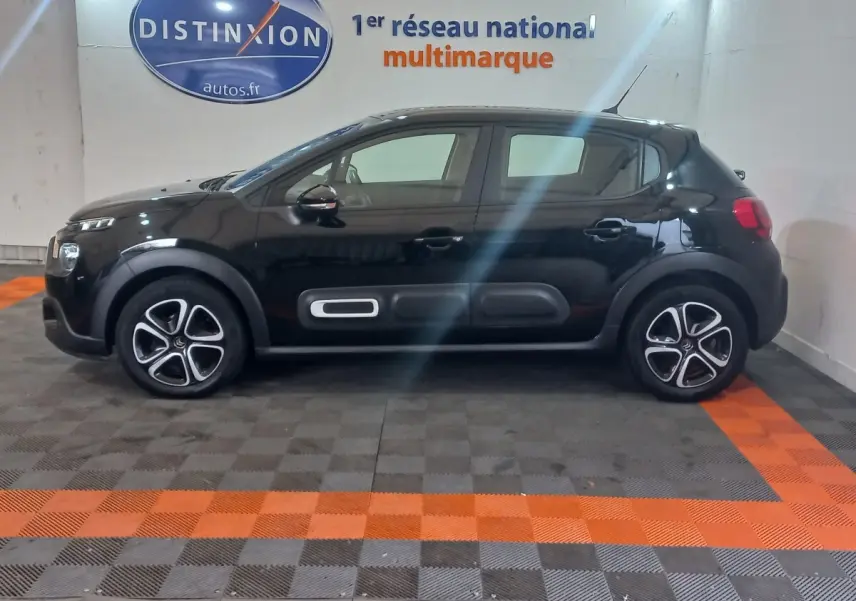 Profil côté gauche d'une Citroën C3 noire 2024 avec protections latérales et jantes distinctives en concession.