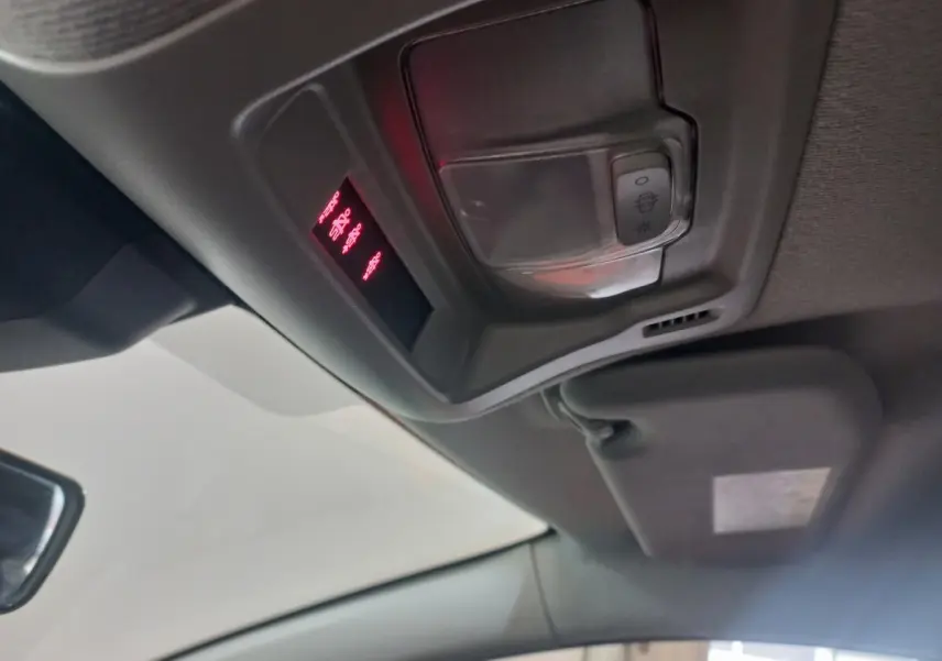 Vue intérieure du plafond avant de la Citroën C3 2024 noire, avec éclairage et commandes de plafonnier visibles.