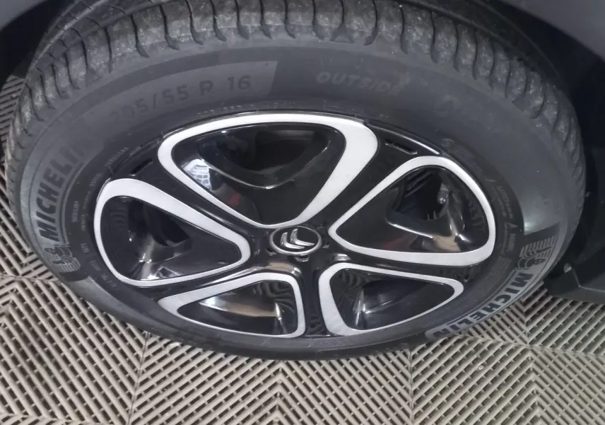 Gros plan sur la roue avant gauche d'une Citroën C3 noire, jante alliage noire et argent avec pneu Michelin.