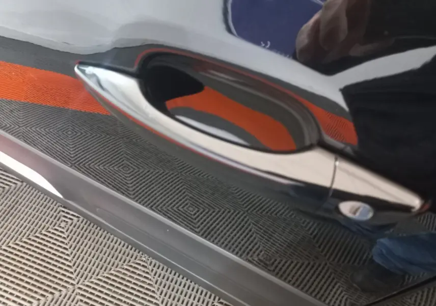 Poignée de porte chromée sur la portière noire côté droit d'une Citroën C3 BlueHDi 100 BVM PLUS 2024.
