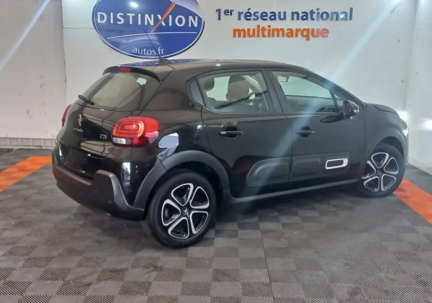 Vue 3/4 arrière droite d'une Citroën C3 noire 2024 avec protections latérales et jantes distinctives.