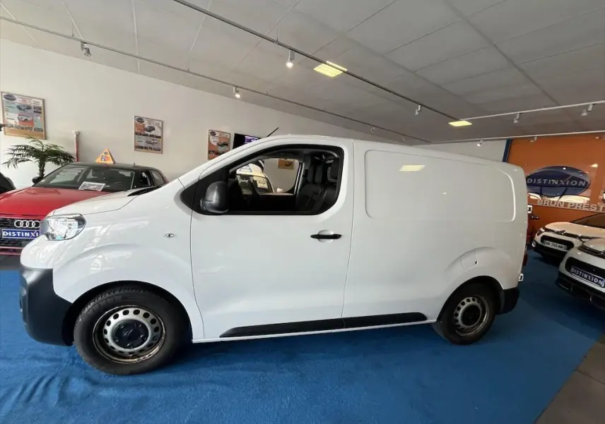 Peugeot Expert Fourgon blanc en vue profil côté gauche, intérieur visible par la porte ouverte en concession.