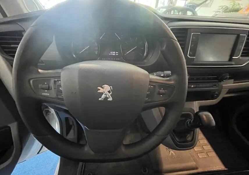 Vue intérieure centrée sur le volant Peugeot noir et le tableau de bord du fourgon blanc Expert 2019.
