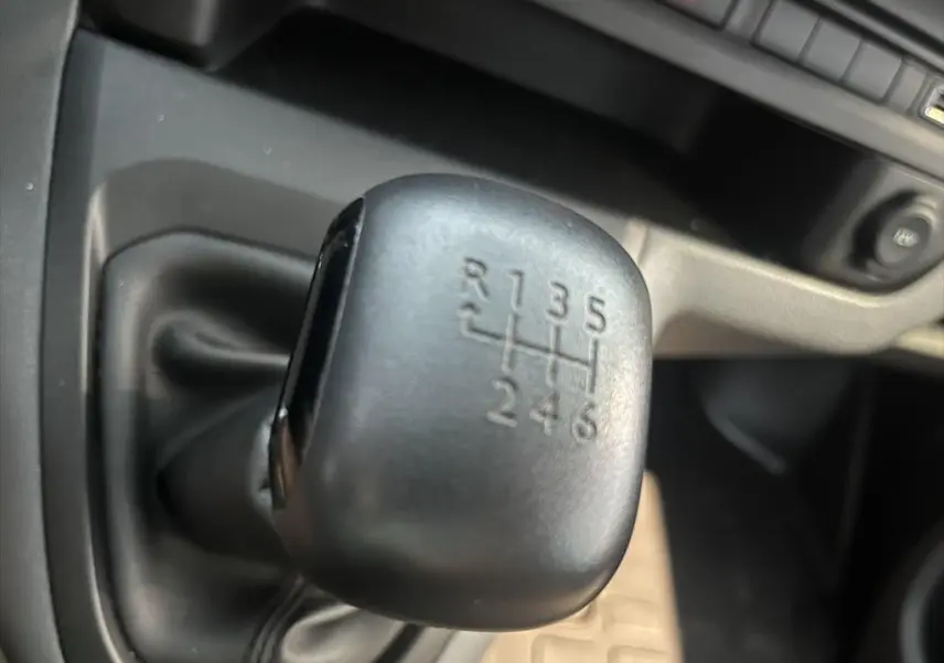 Gros plan sur le levier de vitesses manuel noir du Peugeot Expert Fourgon blanc, montrant les six rapports et la marche arrière.