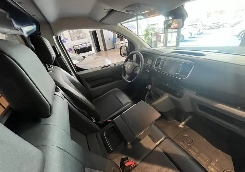 Intérieur noir du Peugeot Expert Fourgon 2019, vue côté conducteur avec tableau de bord et banquette avant modulable.