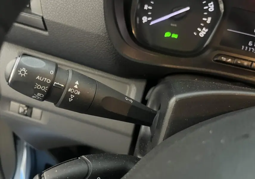 Gros plan sur la commande des phares et clignotants à gauche du volant dans un Peugeot Expert Fourgon blanc 2019.