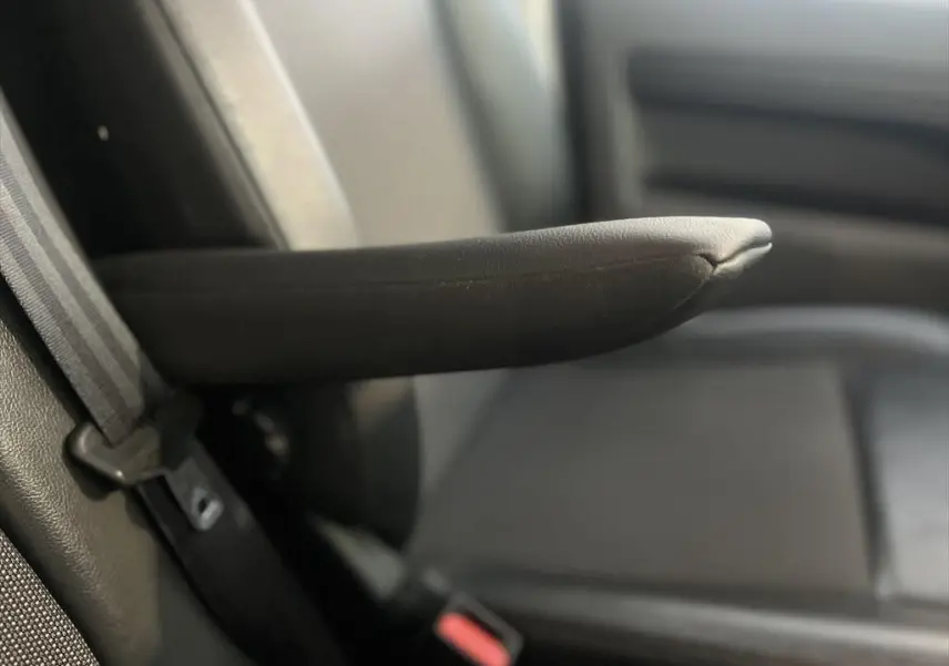 Accoudoir en tissu noir du siège avant gauche du Peugeot Expert Fourgon blanc, vue rapprochée intérieure.