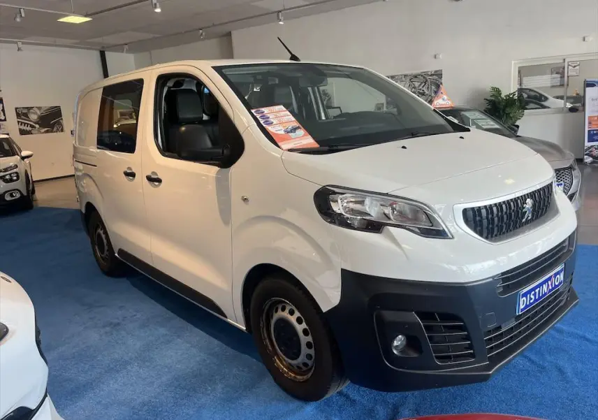 Peugeot Expert Fourgon blanc vu en 3/4 avant droit dans un showroom avec pare-chocs noir et jantes acier.