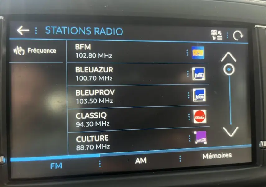 Écran tactile du système radio FM du Peugeot Expert Fourgon blanc, affichant plusieurs stations disponibles.
