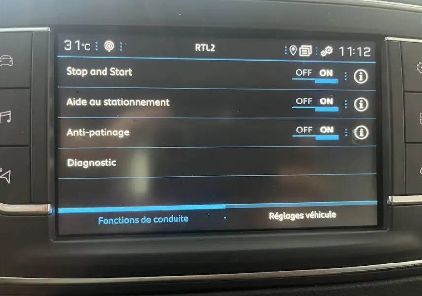 Écran tactile intérieur du Peugeot Expert Fourgon blanc 2019 montrant les réglages d'aide à la conduite activés.