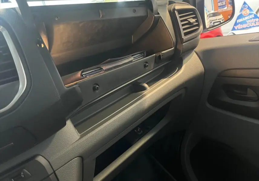 Vue intérieure côté passager du Peugeot Expert Fourgon blanc 2019, avec boîte à gants ouverte et tableau de bord gris noir.