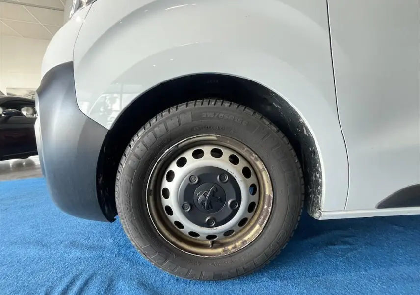 Gros plan sur la roue avant gauche du Peugeot Expert Fourgon blanc, avec jante acier et logo Peugeot central.