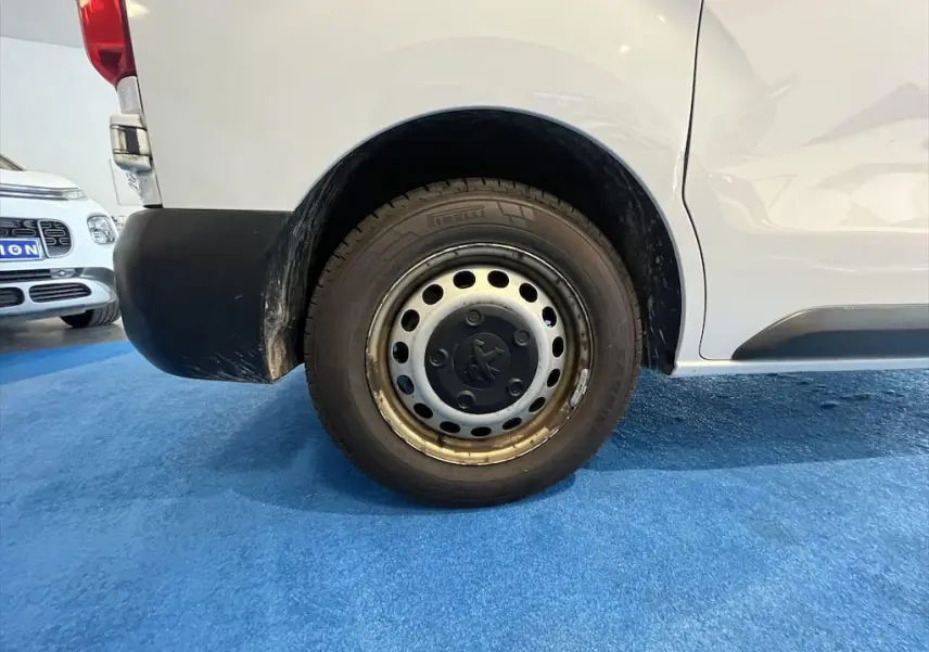 Gros plan sur la roue arrière gauche du Peugeot Expert Fourgon blanc, avec jante acier et logo Peugeot central.