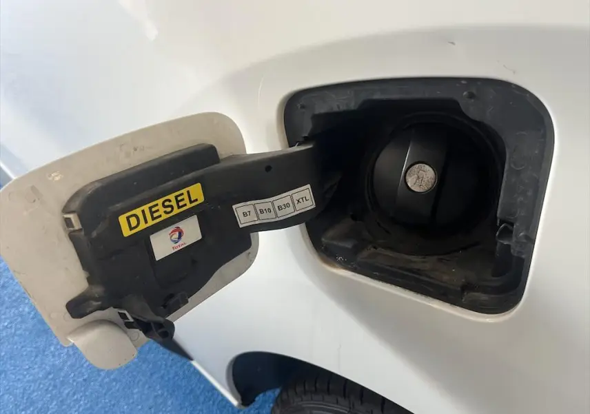 Bouchon de réservoir diesel ouvert côté gauche d'un Peugeot Expert Fourgon blanc, avec étiquette jaune "DIESEL".