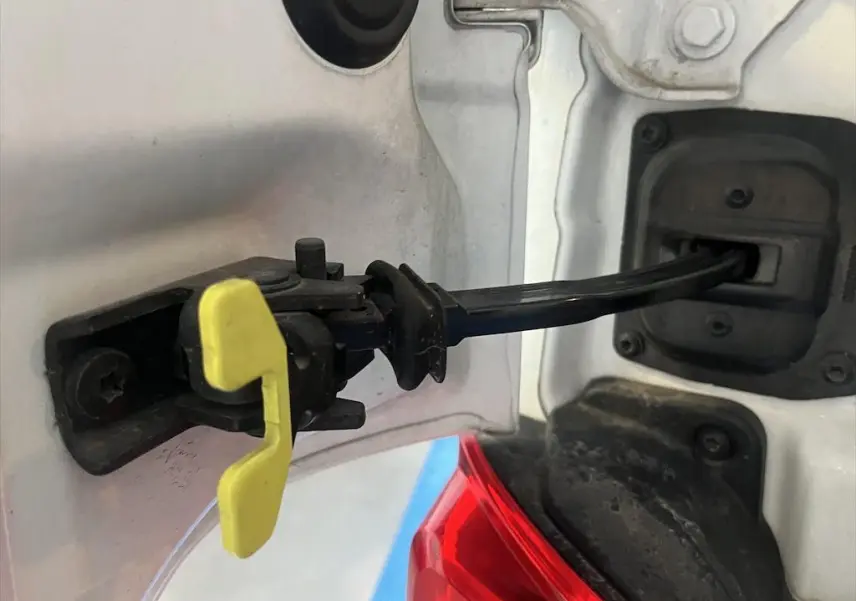 Gros plan sur la charnière de la trappe à carburant blanche du Peugeot Expert Fourgon, avec un détail jaune visible.