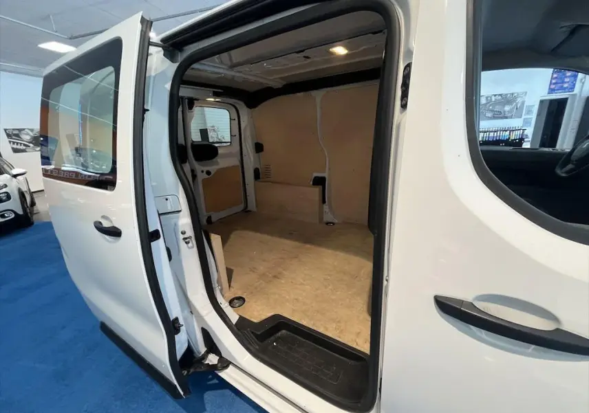 Vue latérale droite du Peugeot Expert Fourgon blanc 2019 avec porte coulissante ouverte montrant l'espace de chargement vide en bois clair.