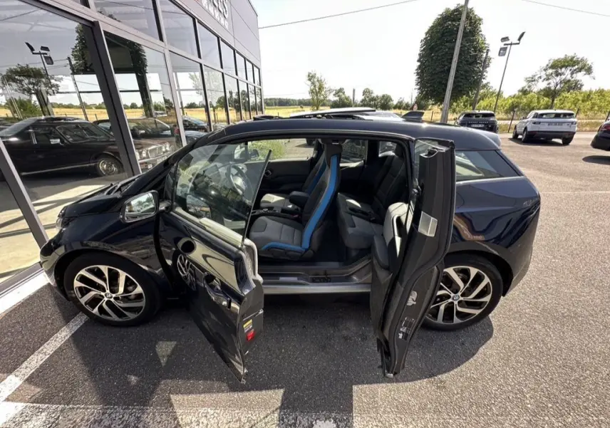 BMW i3 électrique bleue vue de profil gauche avec portes avant et arrière ouvertes montrant l'intérieur.