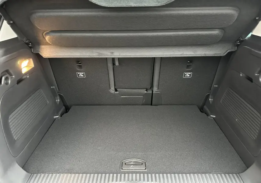 Coffre ouvert vu de l'arrière du Citroën C3 Aircross Noir Perla avec banquette arrière et éclairage intérieur.