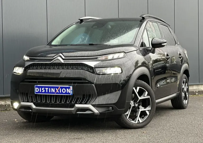 Citroën C3 Aircross noir Perla vue 3/4 avant droit sous la pluie avec jantes alliage et barres de toit noires.