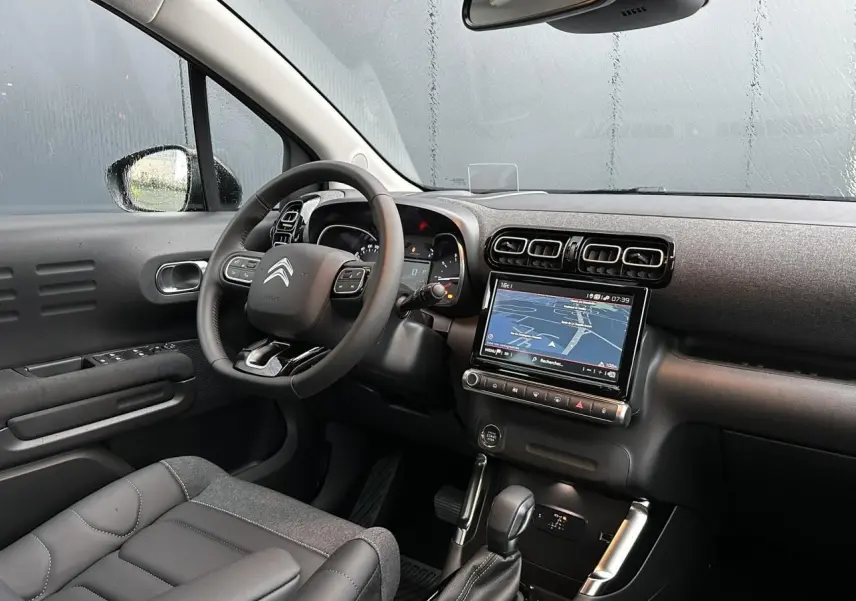 Intérieur avant gauche du Citroën C3 Aircross noir Perla, avec tableau de bord et GPS tactile allumé.