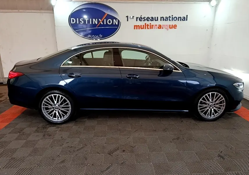 Vue latérale droite d'une Mercedes Classe CLA bleu foncé avec jantes alliage multi-branches en intérieur showroom.