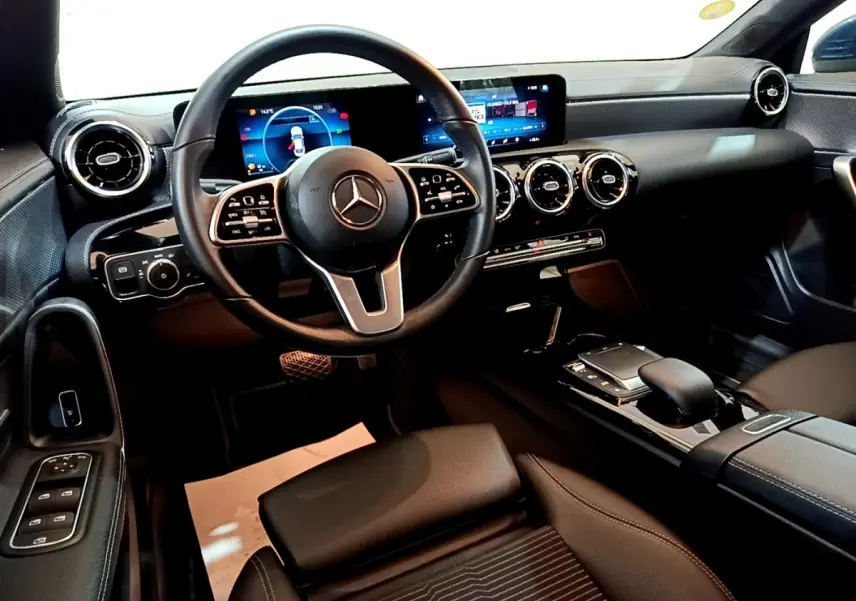 Vue intérieure avant du Mercedes CLA 180 d Business Line 2021, tableau de bord noir avec écran tactile et volant multifonctions cuir alu.