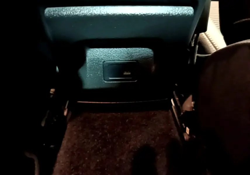 Prise USB arrière sous le siège côté passager d'une Mercedes CLA 180 d Business Line blanche, vue intérieure rapprochée.