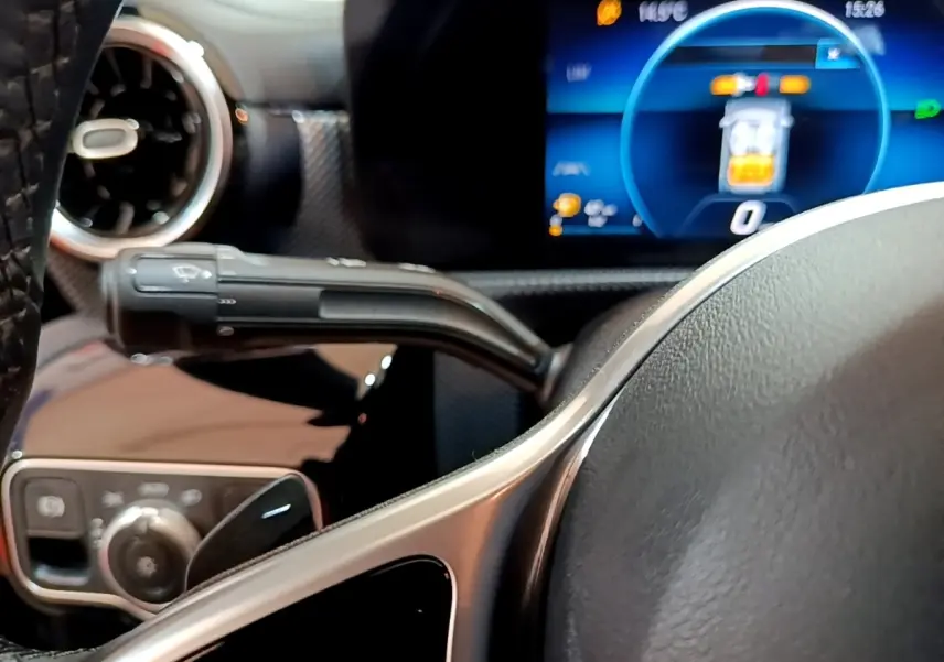 Gros plan sur le volant cuir et alu de la Mercedes CLA 180 d 2021 avec tableau de bord numérique et commandes multifonctions.