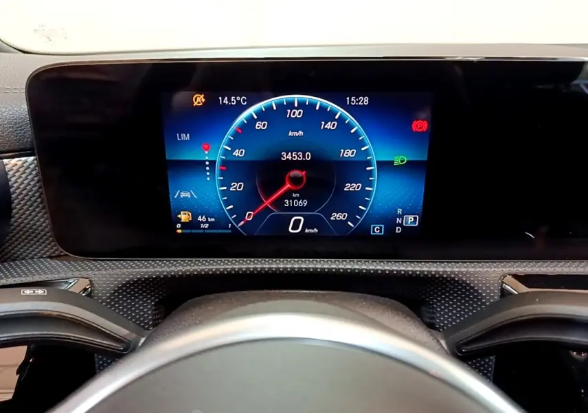 Vue intérieure centrée sur le tableau de bord numérique bleu et noir de la Mercedes CLA 180 d Business Line blanche.