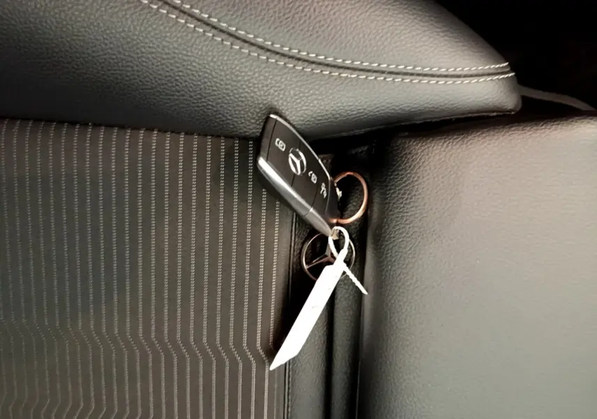 Gros plan sur la clé Mercedes posée sur un siège noir à coutures blanches, intérieur de la CLA 180 d Business Line.