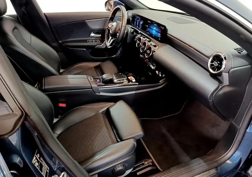 Vue intérieure côté conducteur de la Mercedes CLA 180 d Business Line 2021 avec sièges noirs et tableau de bord numérique.